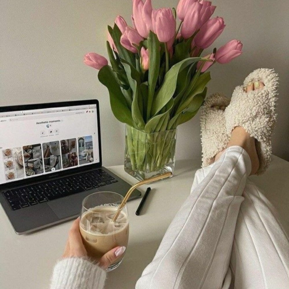 Laptop, tulips and coffee on a cozy desk
