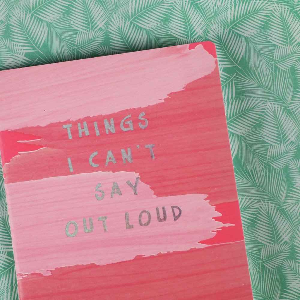 Pink notebook with handwritten cover on mint fabric