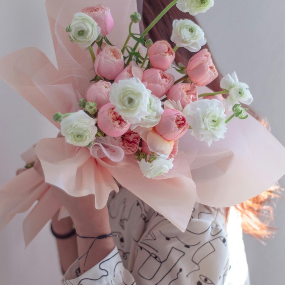 Bouquet of pale pink roses wrapped in paper