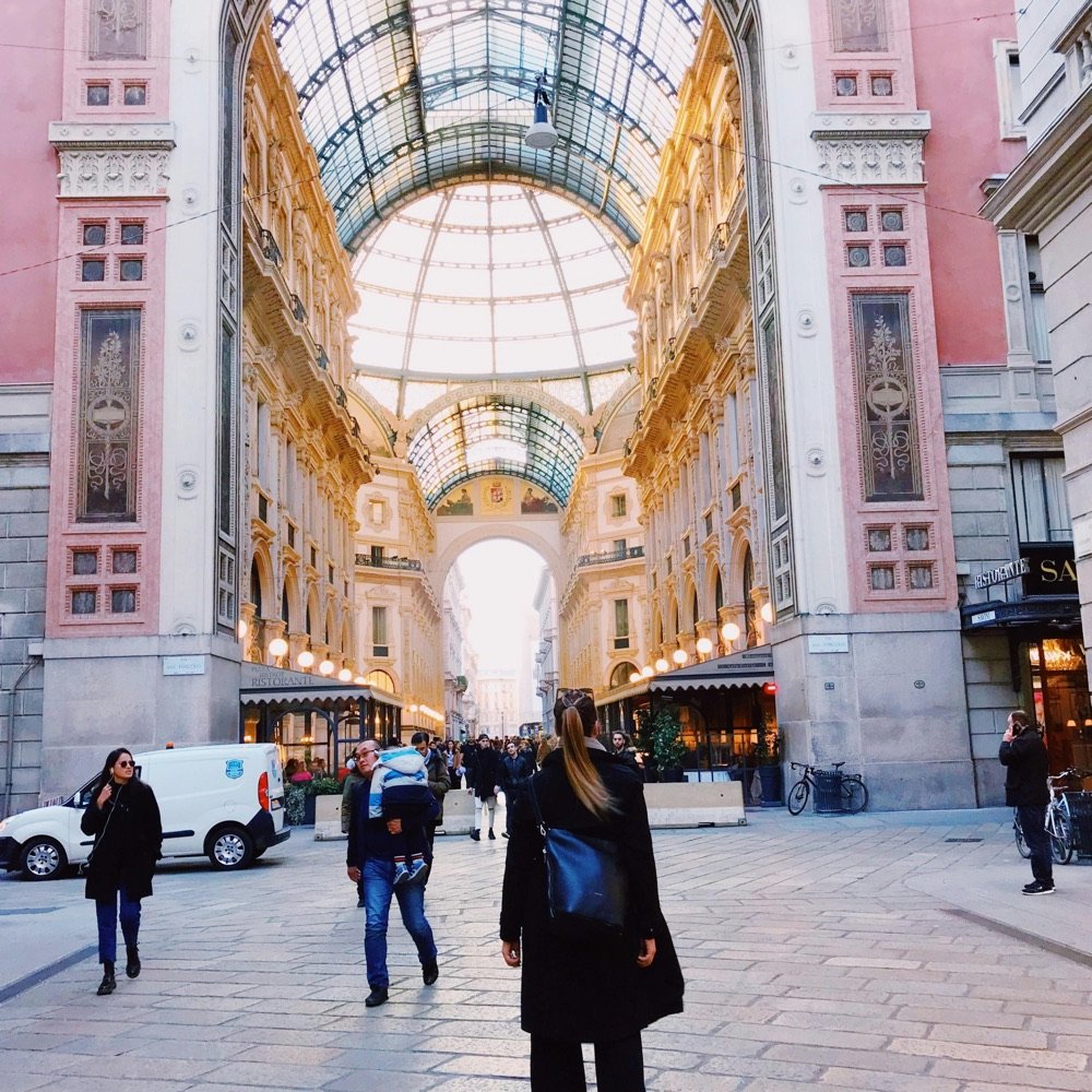 Woman walking through a grand glass-roofed galleria