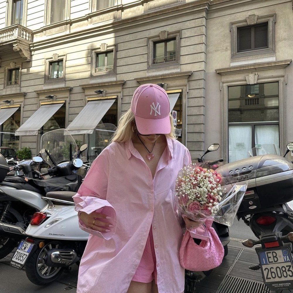 Woman in a pink coat walking a city street