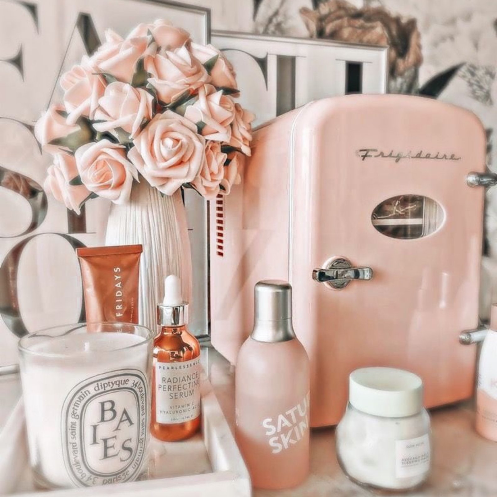 Pink vanity shelf with perfume bottles, roses and skincare